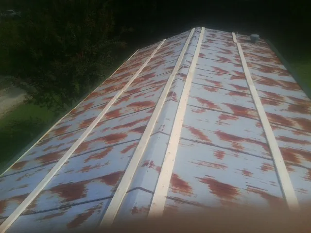 Rusted metal roof panels with new wood purlins before replacement — Storm Damage Roof Repair in North Palm Springs by Roofing Brothers