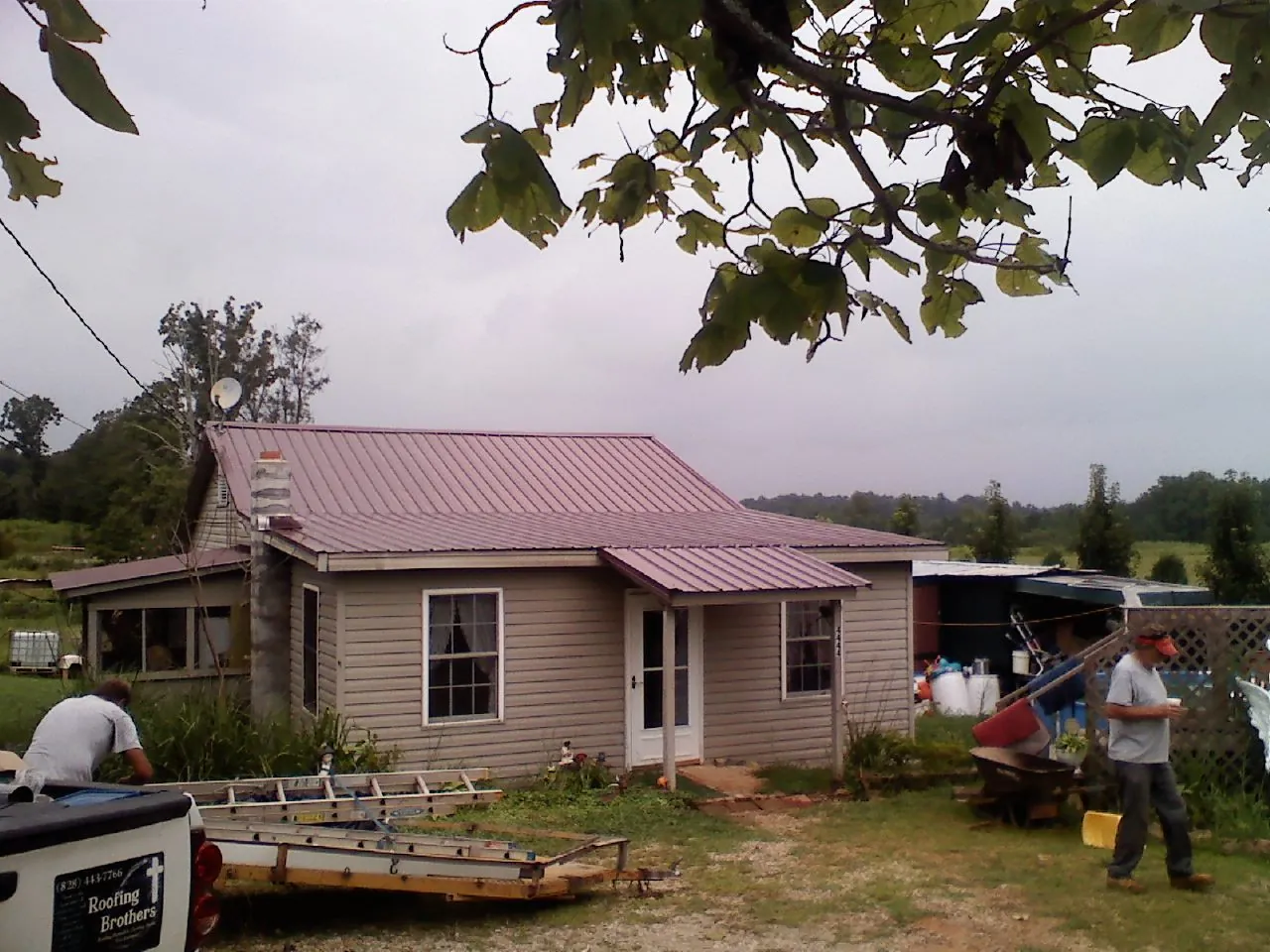 Crew finishing a mauve metal roof on a small farmhouse in North Palm Springs